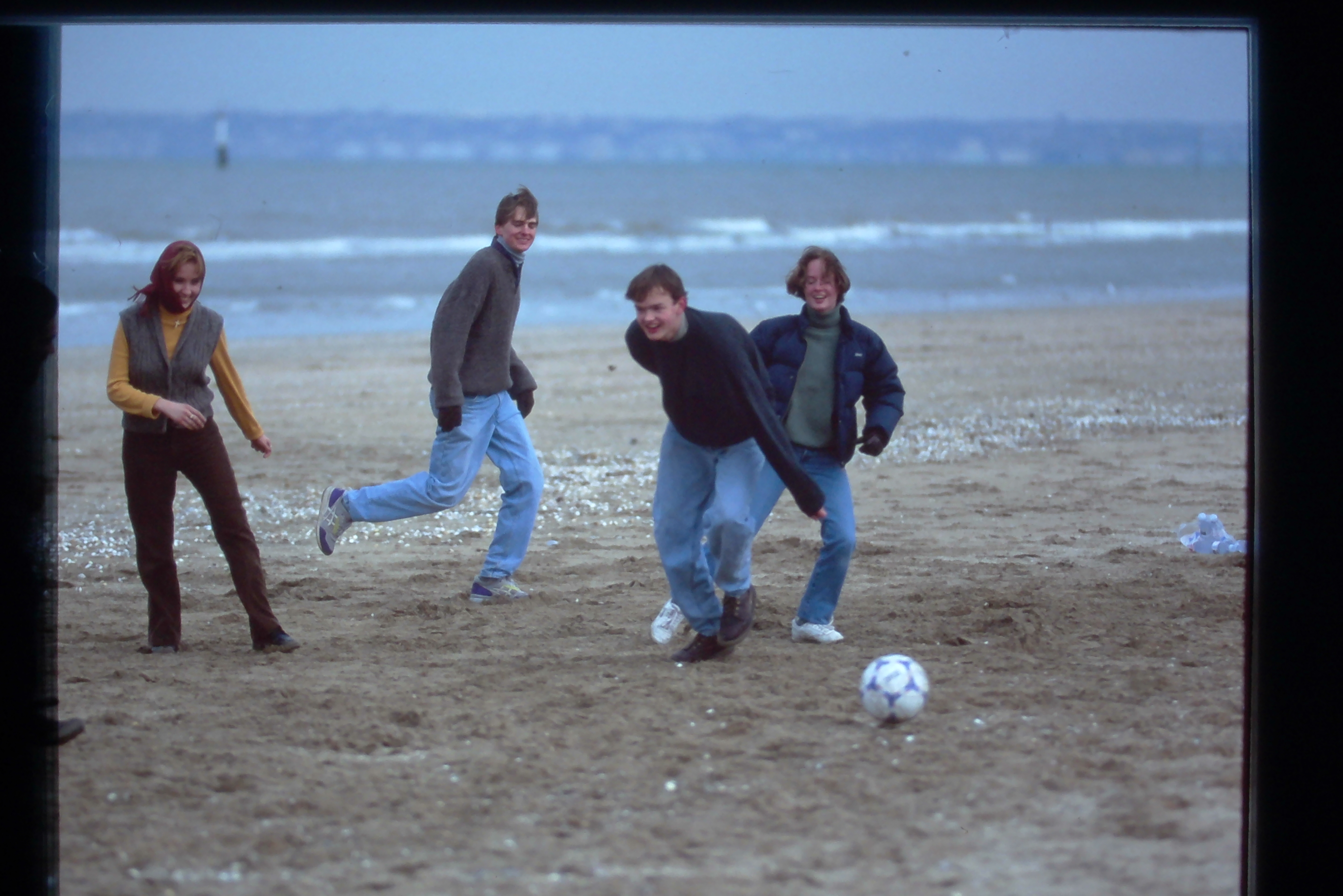 Students playing soccer on the beach
