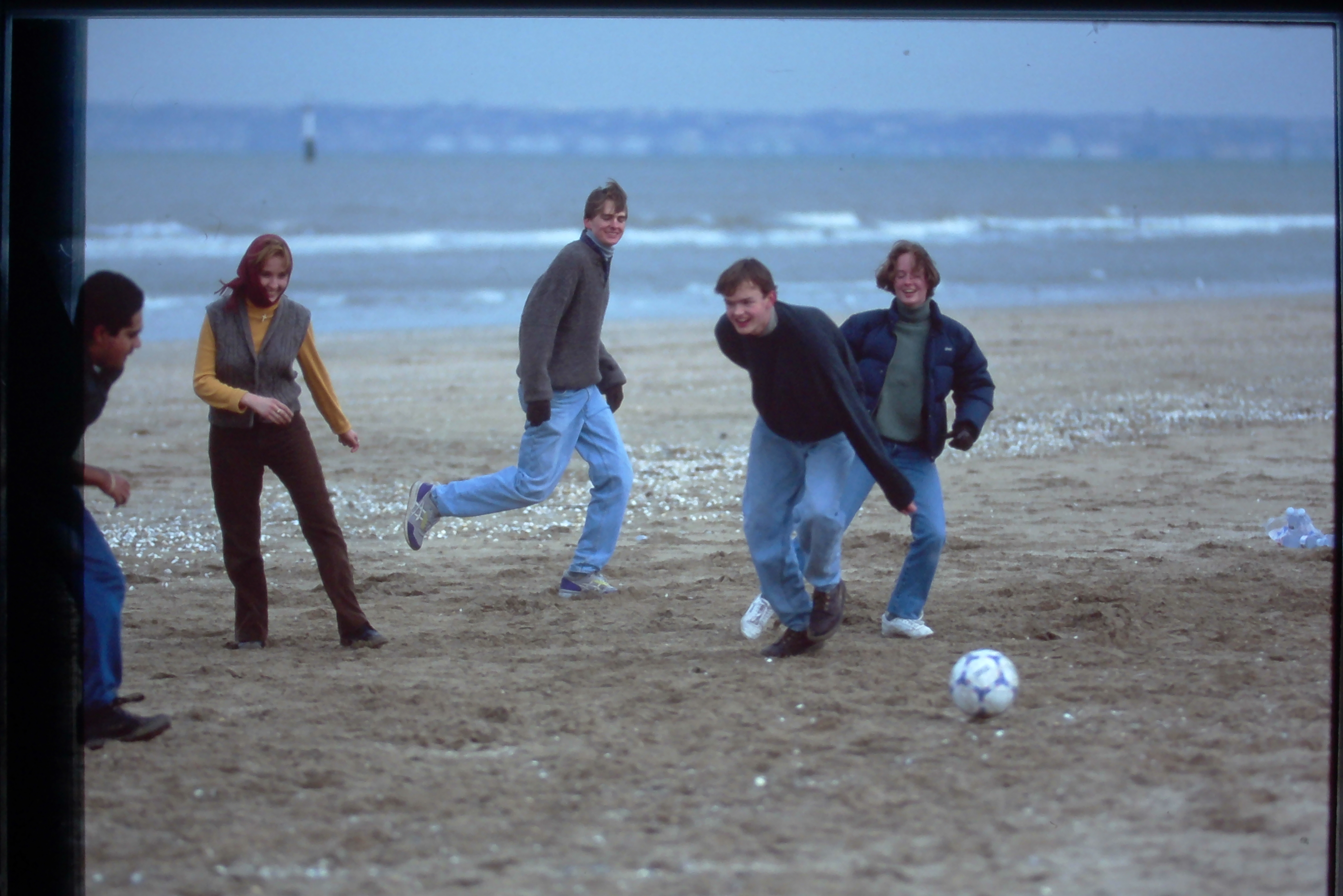 Students playing soccer on the beach